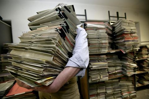 Ein Mann trägt einen Aktenstapel