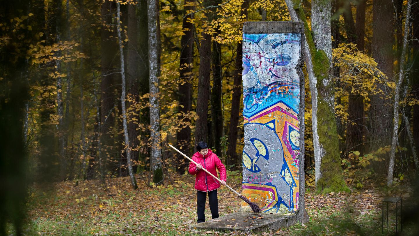 Vilnius, Litauen: Eine Frau fegt ein Segment der Berliner Mauer im Freilichtmuseum der Mitte Europas "Europos Parkas". Litauen war, ebenso wie Estland, ein Teil der Sowjetunion. 1990 erklärte es seine Unabhängigkeit. 