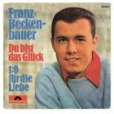 Adrett sieht er aus, der Franz. Das Cover zur Single "Du bist das Glück" hat eine eindeutige Zielgruppe: Schwiegermütter in Spe und deren heiratswillige Töchter. Nach seinem ersten Smash-Hit "Gute Freunde kann niemand trennen", 1966) legte der aufstrebende Superstar des deutschen Fußballs ein Jahr später mit "Du bist das Glück" nach. Die mangelnde stimmliche Ausdrucksfähigkeit versuchte Beckenbauer durch Inbrunst wettzumachen. Ist so halb gelungen.  45football.com