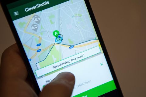 Clever Shuttle: Ein Mann bedient an seinem Smartphone die App des Fahrdienst-Anbieters