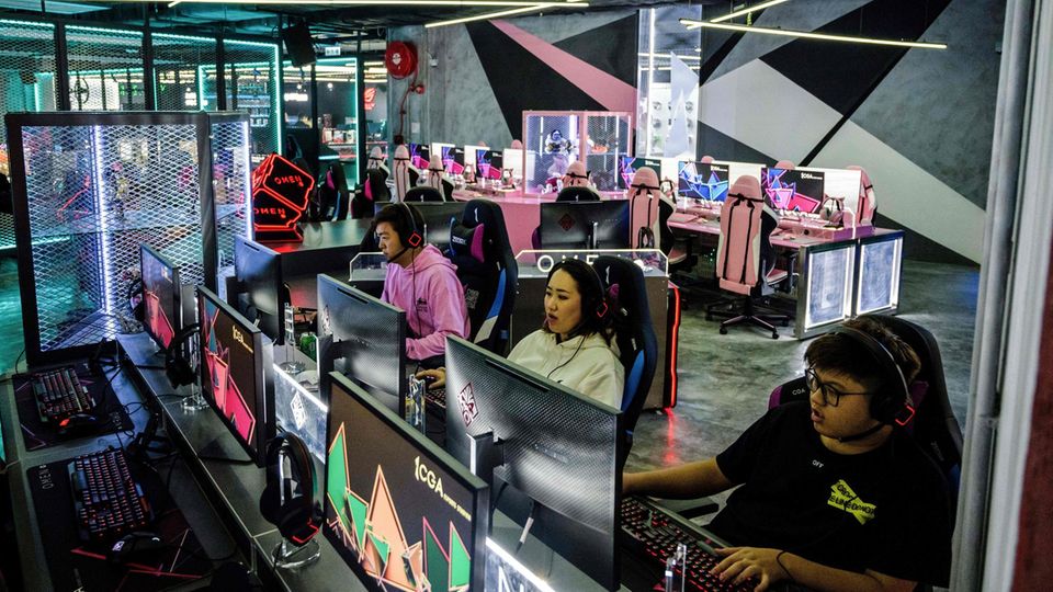 Junge Menschen spielen vor PCs
