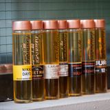 Die kleinen Probefläschchen mit dem kupferfarbenen Verschluss - hier mit diversen Whiskysorten, etwa dem weichen Einsteigerwhisky Nikka Days - wurden zum Markenzeichen von Tastillery.