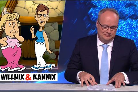 heute-show Moderator Welke schmunzelt über ein Bild, das Merkel und AKK im Asterix-Stil zeigt