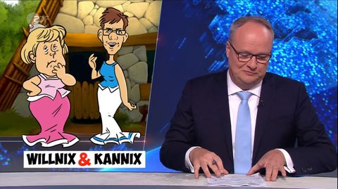 heute-show Moderator Welke schmunzelt über ein Bild, das Merkel und AKK im Asterix-Stil zeigt