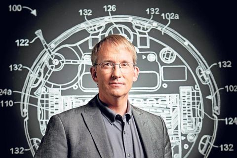 Colin Angle vor der Konstruktionszeichnung eines Saugroboters.