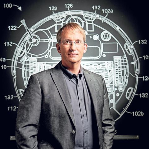 Colin Angle vor der Konstruktionszeichnung eines Saugroboters.