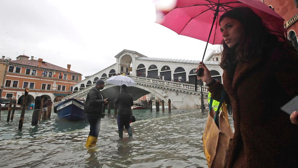 Venedig unter Wasser: Passanten waten in der Nähe der Rialto-Brücke durch die Fluten Venedig unter Wasser: Passanten waten in der Nähe der Rialto-Brücke durch die Fluten