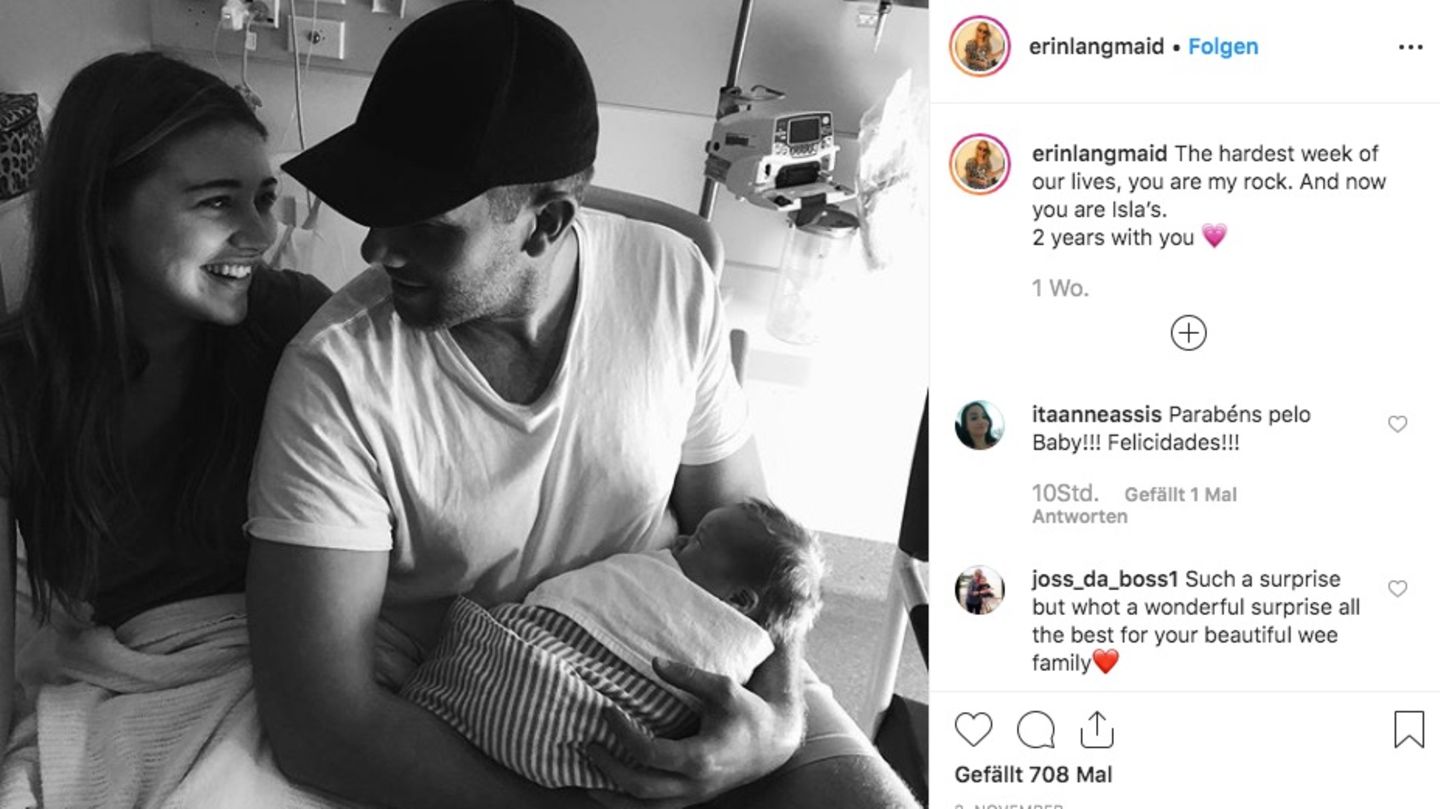 Das Pärchen hält glücklich das Baby im Arm