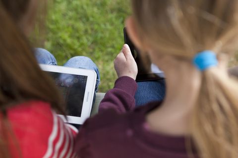 Zwei kleine Mädchen schauen auf ihre Tablet-Computer