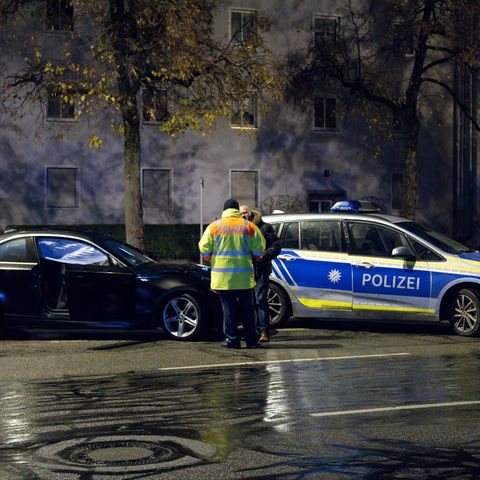 München: Polizisten stehen nach dem Unfall auf der Fürstenrieder Straße neben dem beschädigten Auto