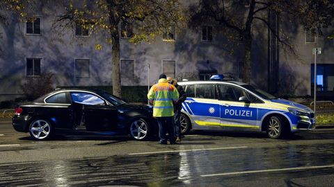 München: Polizisten stehen nach dem Unfall auf der Fürstenrieder Straße neben dem beschädigten Auto