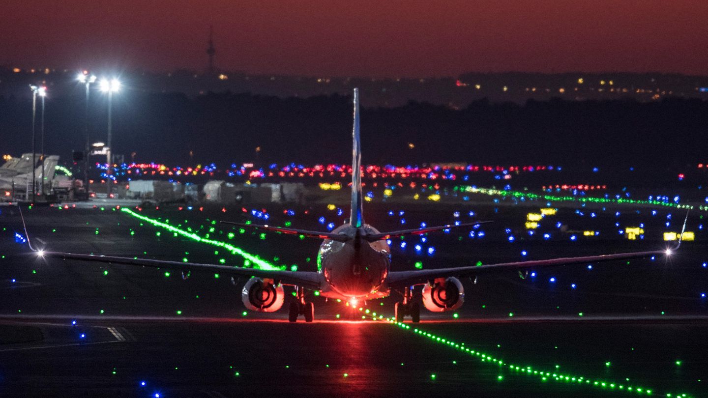 Ein Passagierflugzeug rollt im letzten Licht der untergehenden Sonne über die Rollbahn des Flughafens Frankfurt