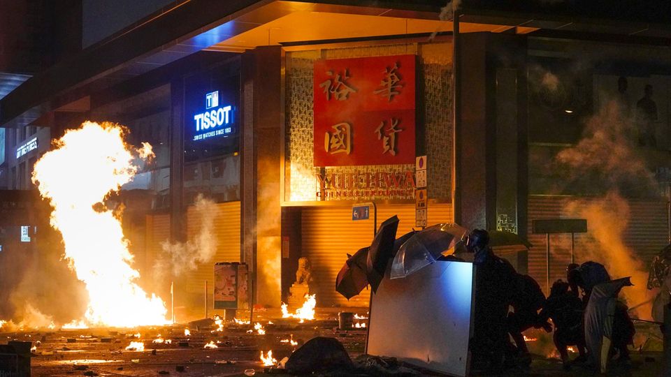 Demonstranten schützen sich auf dem Campus der Polytechnischen Universität in Hongkong mit Regenschirmen vor Tränengasgeschossen der Polizei Demonstranten schützen sich auf dem Campus der Universität in Hongkong mit Regenschirmen vor Tränengasgeschossen