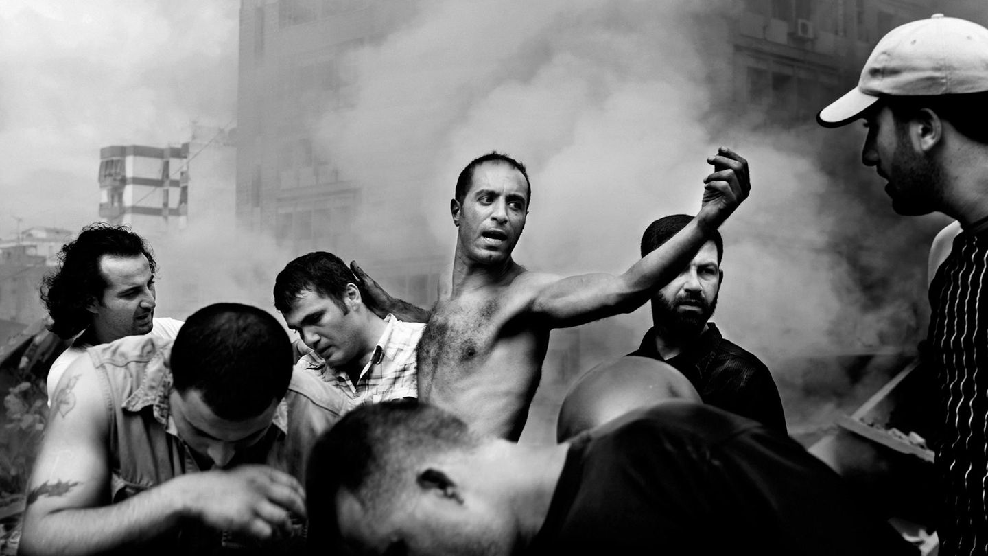 Paolo Pellegrin Eine Gruppe von Männern vor zerstörten Häusern, nachdem ein israelischer Luftangriff mehrere Gebäude in Dahia zerstörte