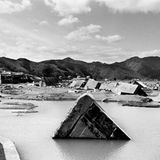 Zerstörte Gebäude ragen aus Wasserlachen