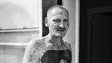 Ein tätowierter Mann mit einem nächtlichen Tattoomotiv auf dem Bauch
