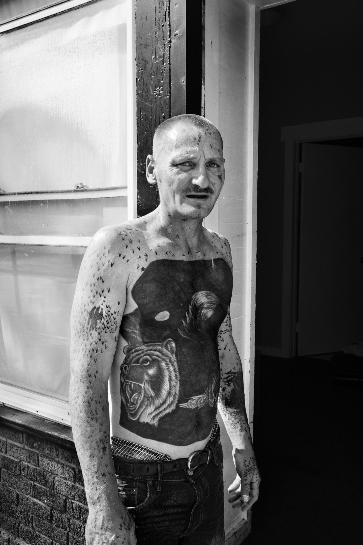 Ein tätowierter Mann mit einem nächtlichen Tattoomotiv auf dem Bauch