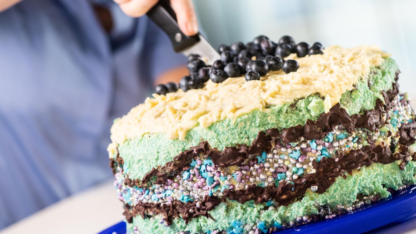 Fettleber: Die neue Volkskrankheit? Frau schneidet mit einem Messer eine Buttercremetorte an