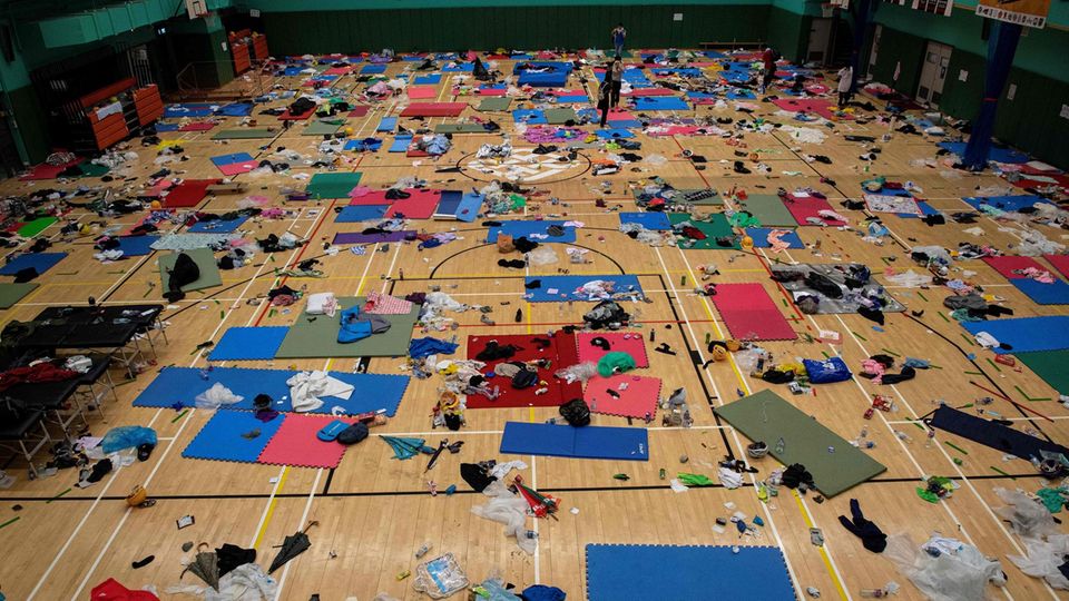 Schlafmatten, Müll und Kleidung liegen in einer Sporthalle der besetzten Hochschule