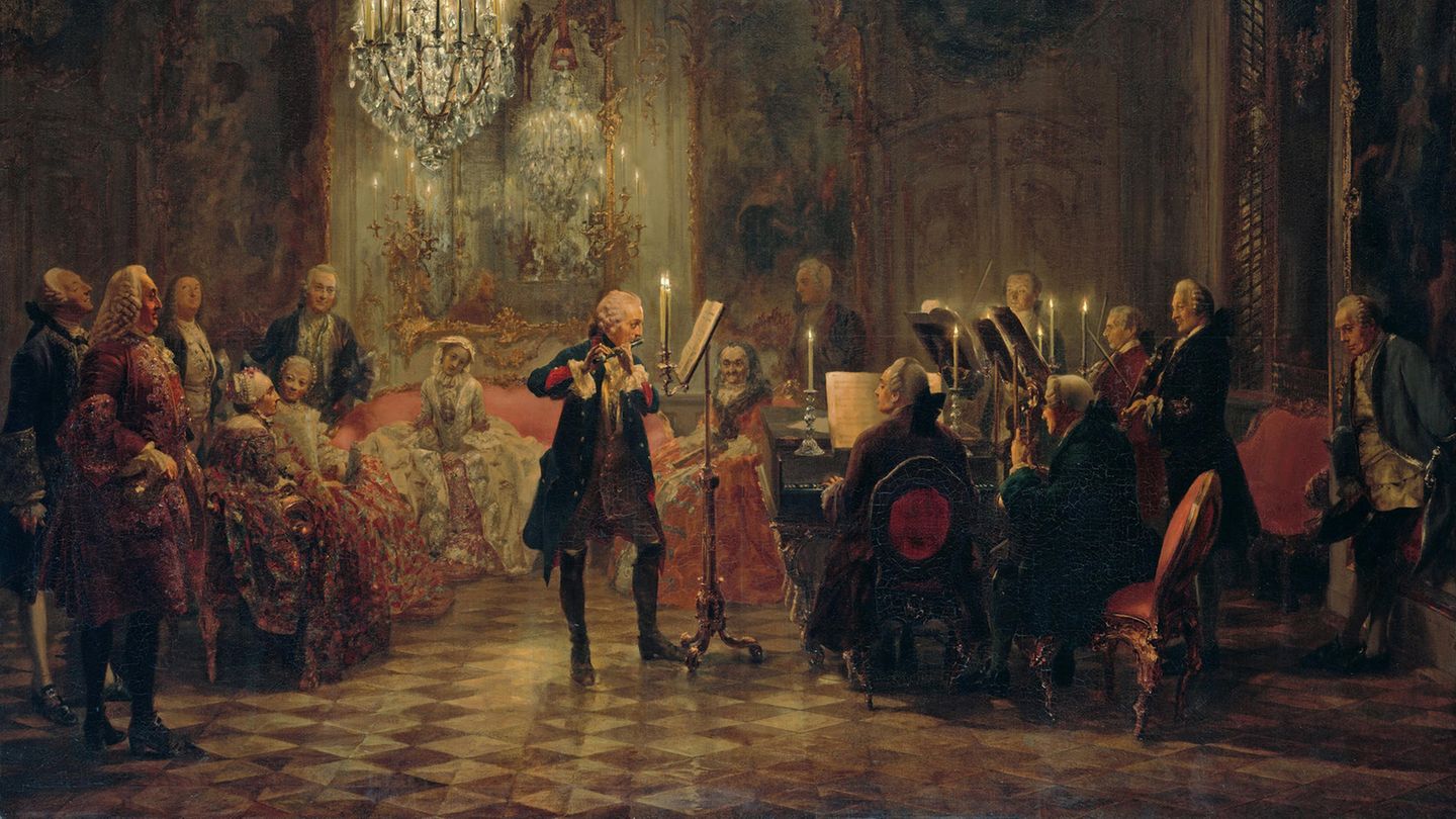 Ein Gemälde auf dem Friedrich der Große abgebildet ist. Er spielt Querflöte, begleitet vom Kammerorchester