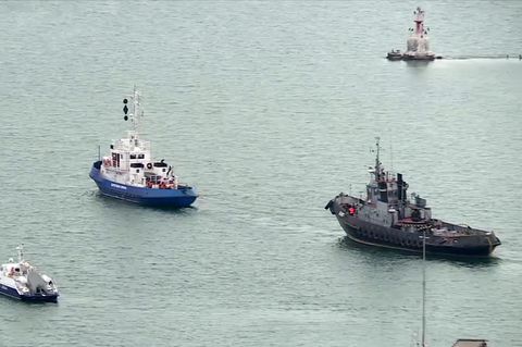 Ein beschlagnahmtes ukrainisches Schiff (r) wird aus dem Hafen von Kertsch geschleppt
