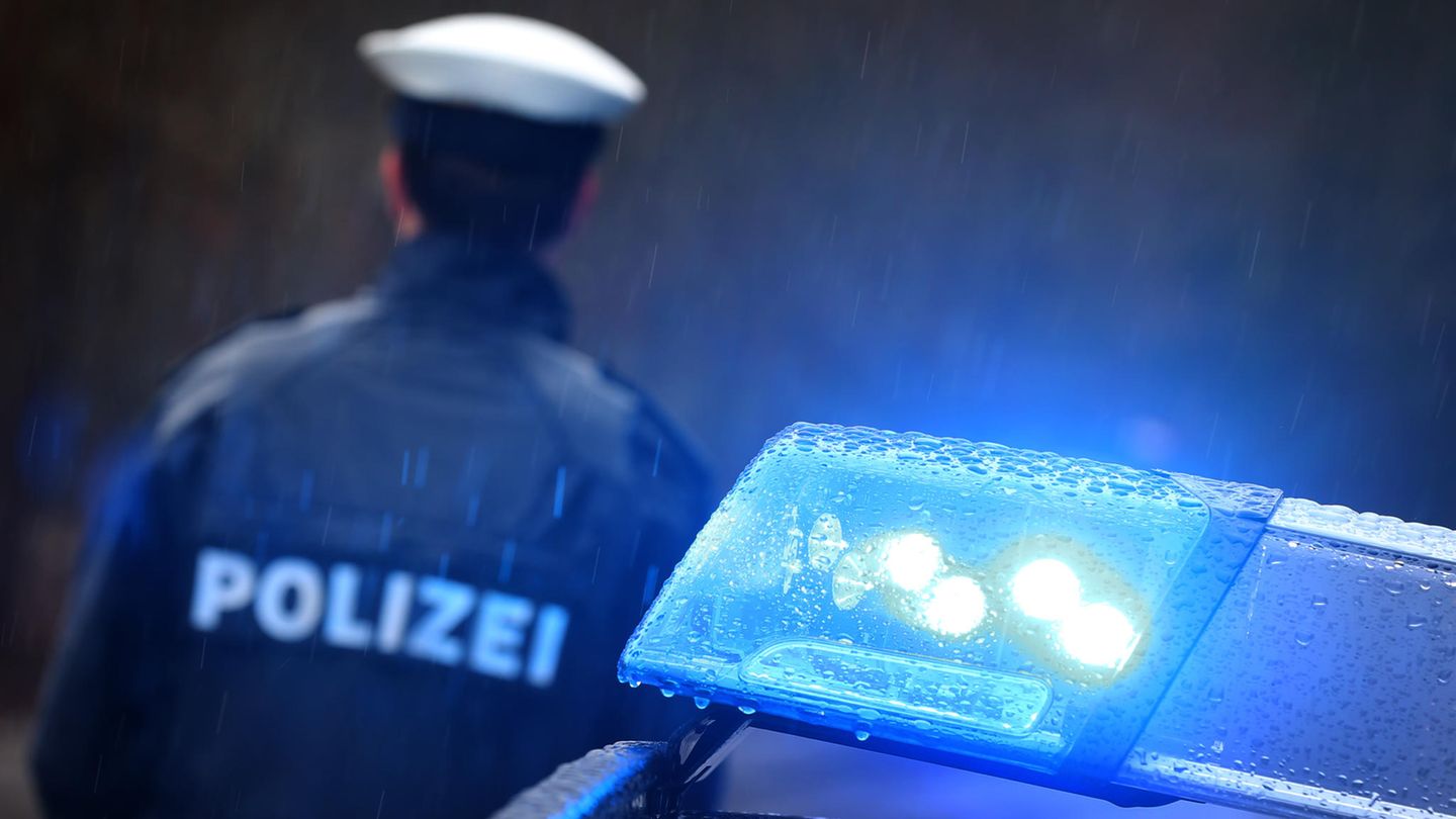 News von heute: Ein Polizist steht neben einem Einsatzwagen mi Blaulicht