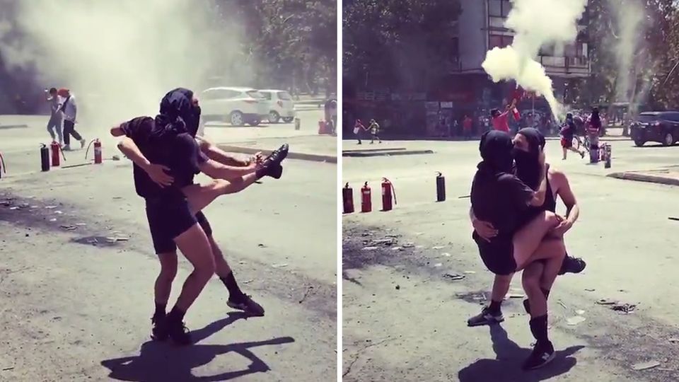 Inmitten heftiger Proteste tanzen zwei Demonstranten auf der Straße in Chile.