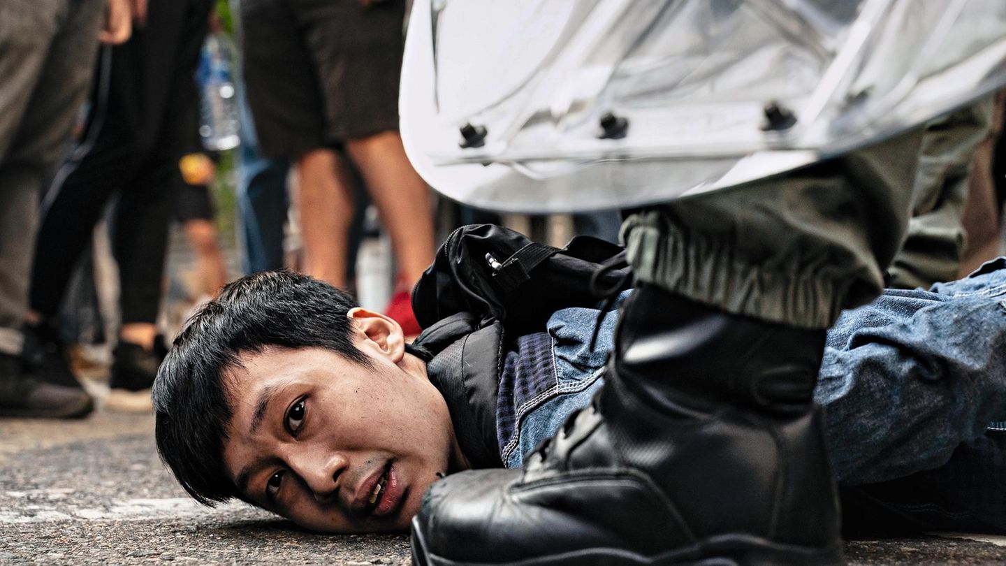 Chinesische Polizisten nehmen einen der Demonstranten fest Chinesische Polizisten nehmen einen der Demonstranten fest