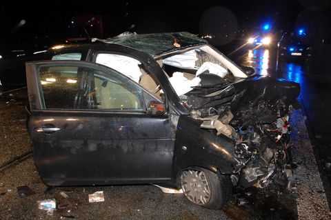 Ein total demoliertes Auto in der Dunkelheit