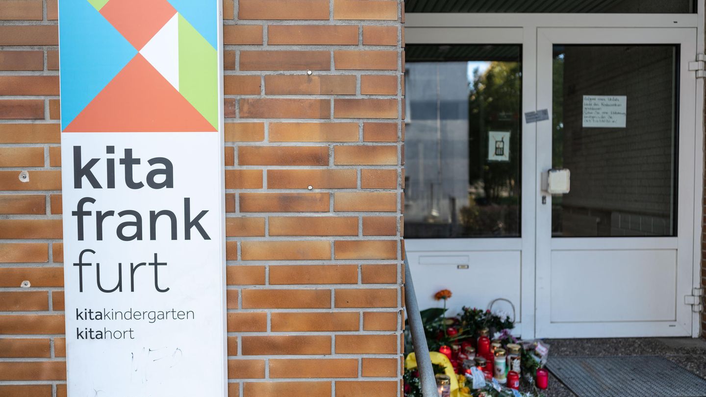 Blumen und Kerzen (r) sind am Eingang zu einer Kindertagesstätte im Stadtteil Seckbach abgelegt.