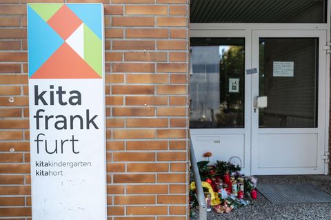 Blumen und Kerzen (r) sind am Eingang zu einer Kindertagesstätte im Stadtteil Seckbach abgelegt.