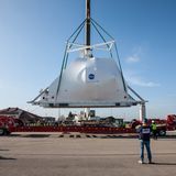 Ein Kran hievt das Raumfahrzeug der Nasa, das in Zusammenarbeit mit der European Space Agency (ESA) gebaut wird, auf einen Sattelschlepper.