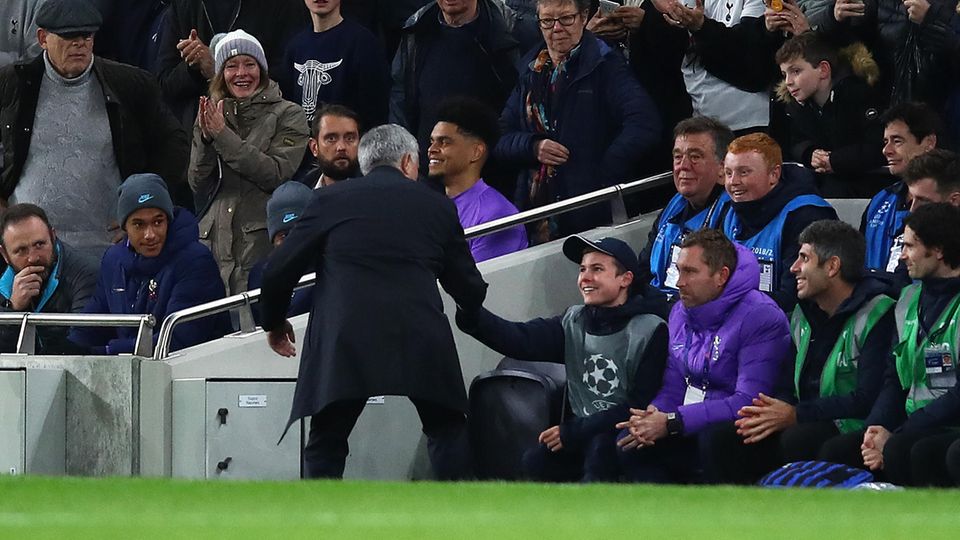 Jose Mourinho klatscht am Spielfeldrand mit einem Balljungen ab