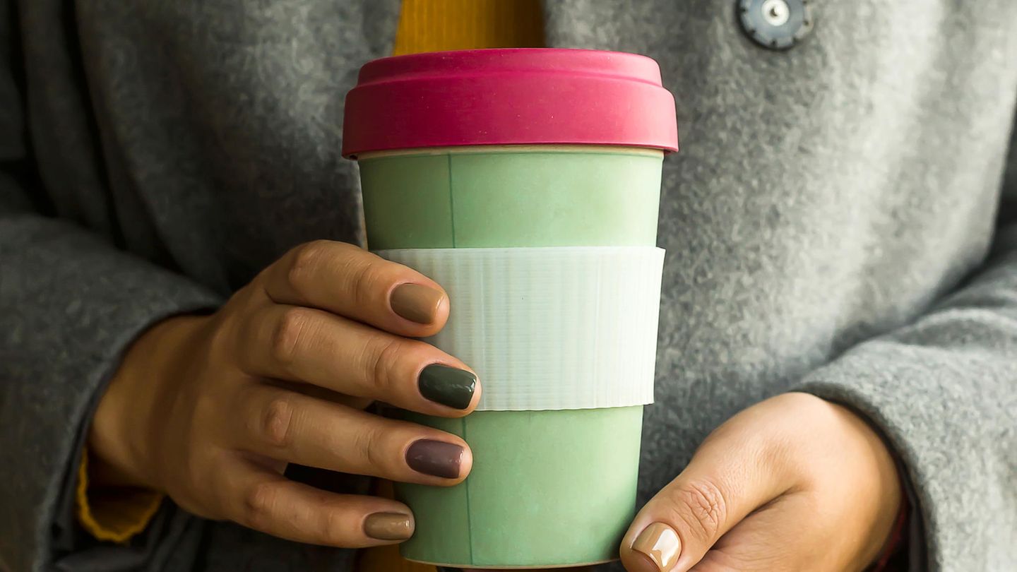 Eine Frau hält einen Becher aus Bambus