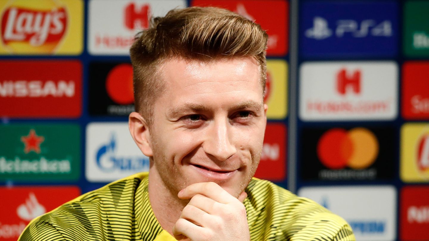 Marco Reus lächelt auf der Pressekonferenz den Journalisten zu