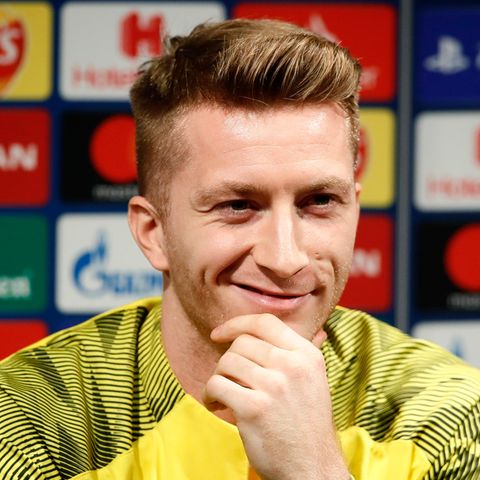 Marco Reus lächelt auf der Pressekonferenz den Journalisten zu