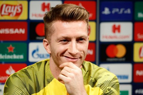 Marco Reus lächelt auf der Pressekonferenz den Journalisten zu