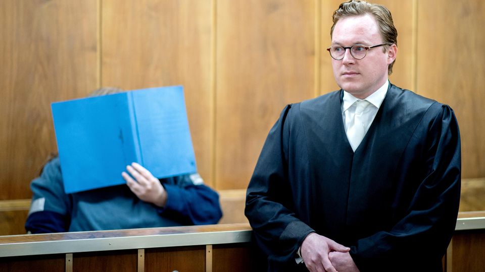 News von heute: Der angeklagte Sohn sitzt mit einem Aktendeckel vor dem Gesicht hinter seinem Verteidiger Pascal Ackermann im Gerichtssaal. Im Prozess gegen einen Waffensammler, der in rechtsextremen Internet-Foren unterwegs war, wurde am Mittwoch das Urteil gesprochen. Der angeklagte Sohn sitzt mit einem Aktendeckel vor dem Gesicht hinter seinem Verteidiger Pascal Ackermann im Gerichtssaal. Im Prozess gegen einen Waffensammler, der in rechtsextremen Internet-Foren unterwegs war, wurde am Mittwoch das Urteil gesprochen.