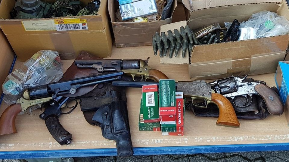 Schusswaffen und Munition liegen auf einem Tisch Schusswaffen und Munition liegen auf einem Tisch