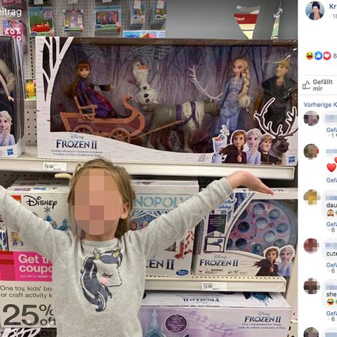 Emerson steht vor der Produktpalette des Filmes "Frozen" und strahlt