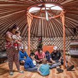 KM 10.740: In der Mongolei werden sie von der Familie Bak-Tuluk in die Jurte eingeladen. "Draußen grasen noch dreißig Huftiere, ein bunter Mix aus Pferden, Yaks, Ziegen und Schafen, das lebende Vermögen der Nomadenfamilie. Mehr besitzen sie nicht, außer noch der Jurte, der Mitgift ihres Mannes Temudschin." 