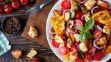 Panzanella  Um die Erfindung dieses italienischen Klassikers ranken sich einige Geschichten. Die einen sagen, er sei aus der Not heraus von Fischern entstanden, weil die nicht so viel Platz gehabt hätten, eine ordentliche herzhafte Mahlzeit zuzubereiten. Die anderen sagen, dass es ein Gericht aus der Armen-Leute-Küche ist, die so altbackenes Brot wiederverwertet haben. Welche Geschichte auch stimmt, Fakt ist, dass die Panzanella zu den berühmtesten italienischen Salaten gehört. Er besteht aus altbackenem Brot, roten Zwiebeln und Tomaten. Häufig wird noch frische Gurke, Basilikum, Essig und Öl dazugegeben.