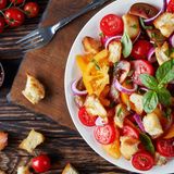Panzanella  Um die Erfindung dieses italienischen Klassikers ranken sich einige Geschichten. Die einen sagen, er sei aus der Not heraus von Fischern entstanden, weil die nicht so viel Platz gehabt hätten, eine ordentliche herzhafte Mahlzeit zuzubereiten. Die anderen sagen, dass es ein Gericht aus der Armen-Leute-Küche ist, die so altbackenes Brot wiederverwertet haben. Welche Geschichte auch stimmt, Fakt ist, dass die Panzanella zu den berühmtesten italienischen Salaten gehört. Er besteht aus altbackenem Brot, roten Zwiebeln und Tomaten. Häufig wird noch frische Gurke, Basilikum, Essig und Öl dazugegeben.