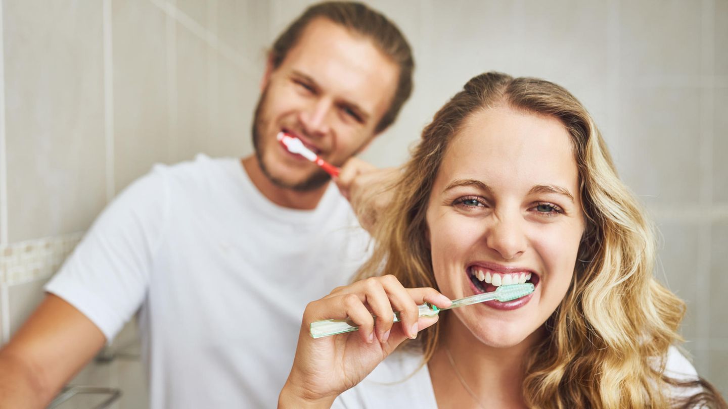 Zahngesundheit und Herz: Ein junges Paar putzt sich die Zähne