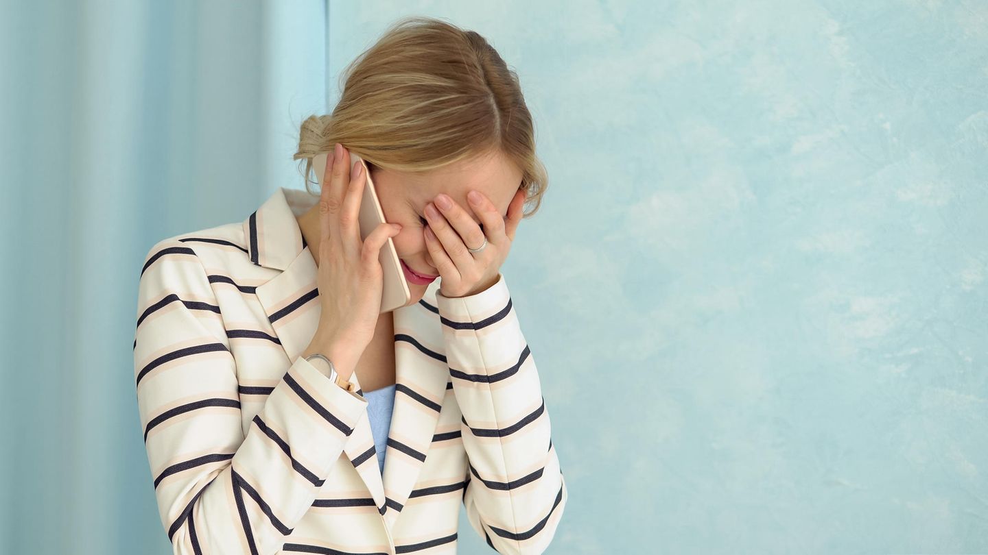 Frau erschrocken am Telefon
