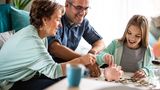 9- bis 2-Jährige sollten verstanden haben, dass Dinge etwas kosten - und dass es unterschiedliche Preise gibt. Dass Schuhe teurer sind als ein Brötchen. In diesem Alter ist es auch ratsam, ein Sparkonto zu haben.