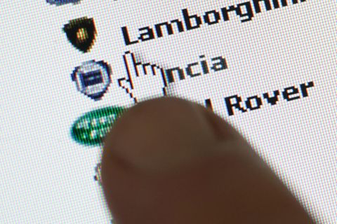 Ein Finger zeigt auf eine Anzeige in einem Internet-Portal für Autos