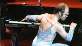 Elton John spielt bei einem Konzert auf einem Flügel