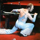 Elton John spielt bei einem Konzert auf einem Flügel