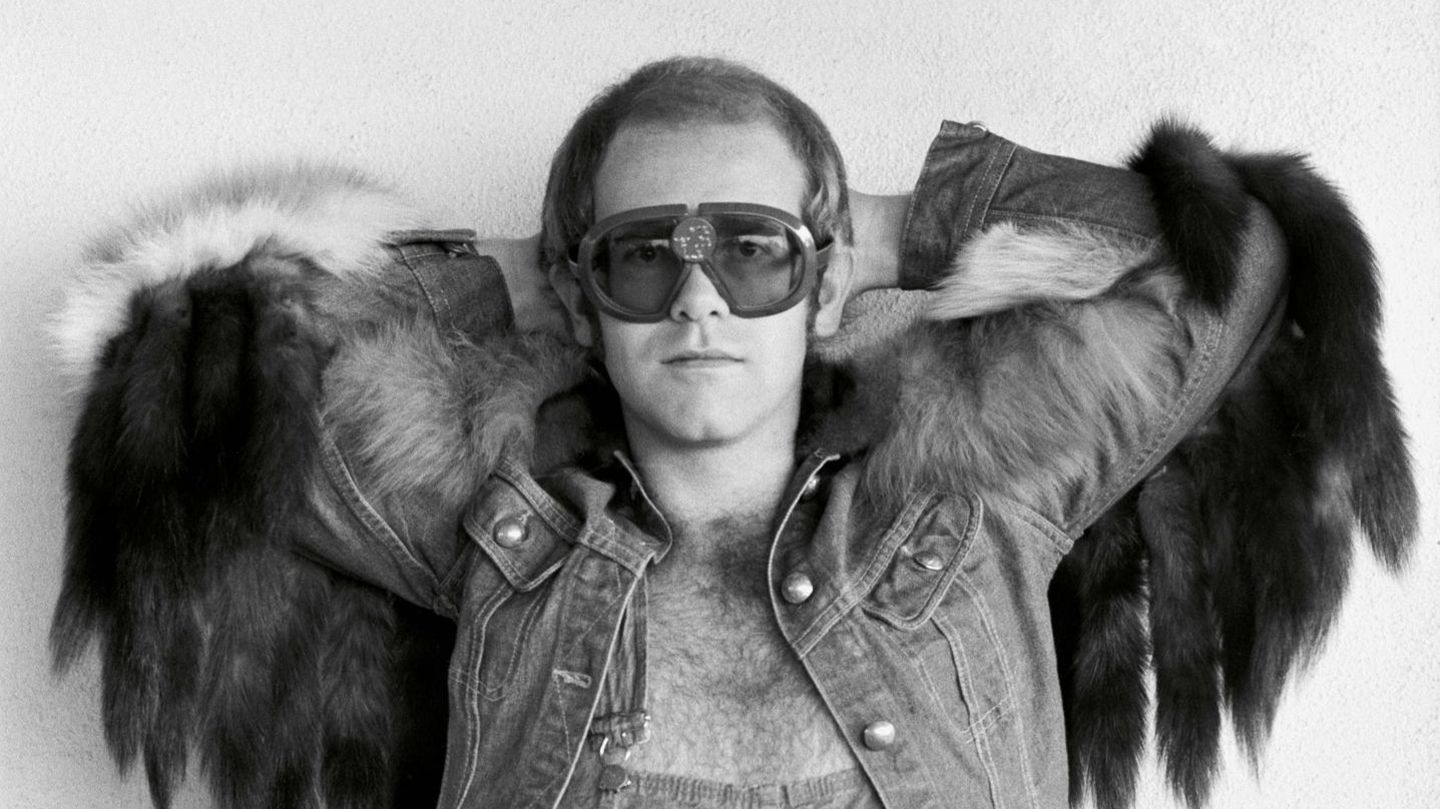 Elton John Elton John in Latzhose und Jeansjacke mit Fell